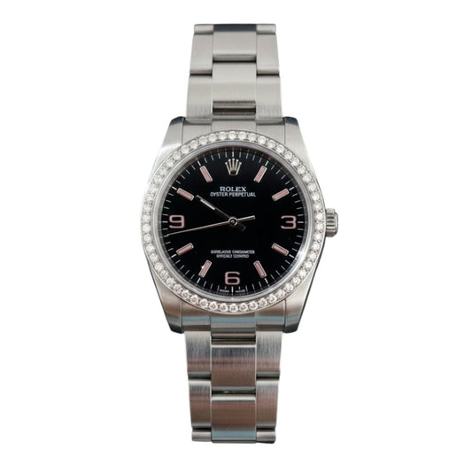 Silver watch with black face and diamond bezel on a white background