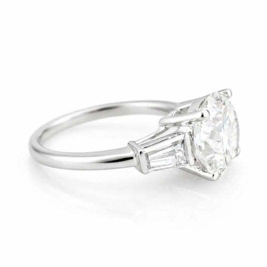 Diamond ring with a large central diamond and smaller baguette-cut diamonds on a white background