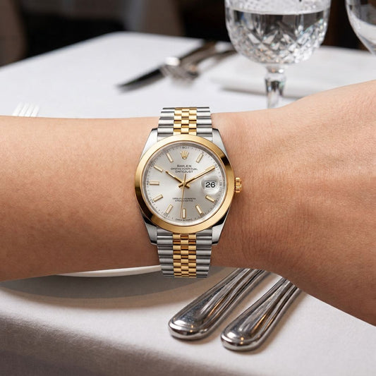A two-tone Rolex Datejust watch with a gold and silver link bracelet and a champagne dial, worn on a person's wrist in a restaurant setting.