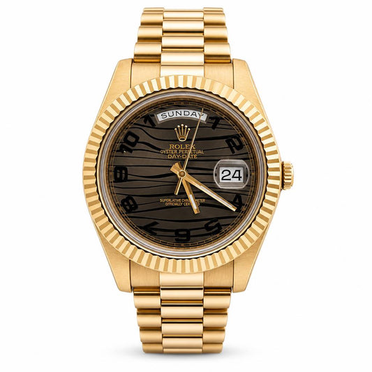 A Rolex Day Date watch with a gold-tone metal case, fluted bezel, and integrated bracelet, featuring a dark brown zebra-stripe dial with a day and date display.